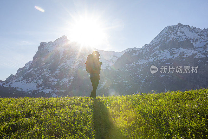 女性徒步者攀登草甸斜坡，在山上