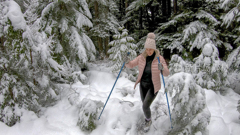 一名女性徒步旅行者穿过白雪覆盖的森林