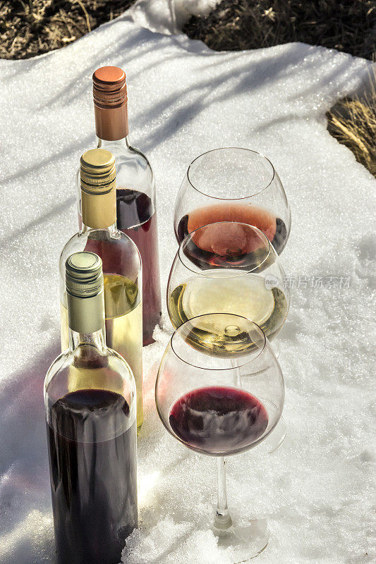 红色，rosé和白葡萄酒在新鲜的雪上。