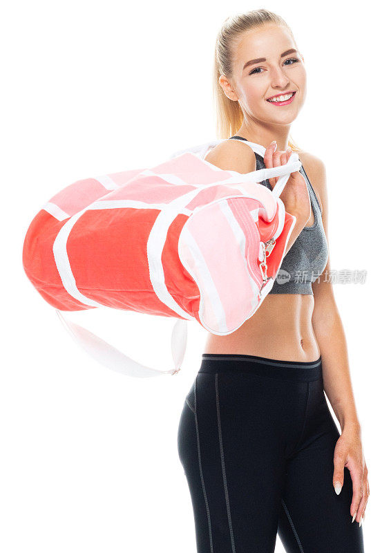 z一代女性穿着运动胸罩，拿着运动包在白色背景前锻炼