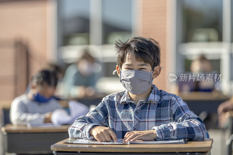 学生戴着面具在户外教室里