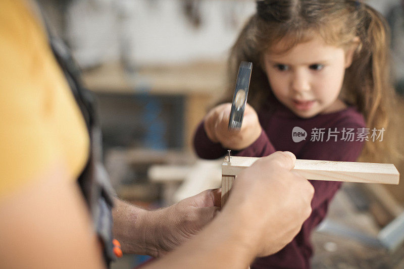 父亲和女儿在车间制作木架