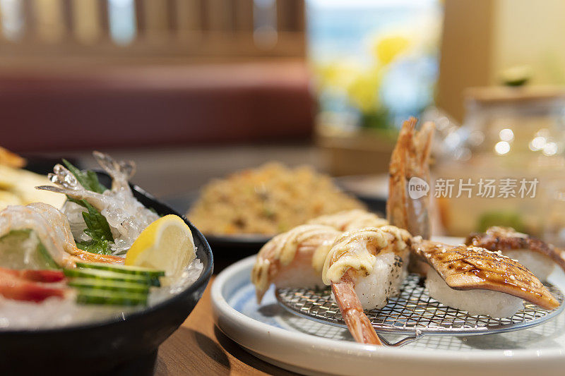 日本料理像生鱼片，寿司，沙拉，炒饭和海鲜汤在餐厅