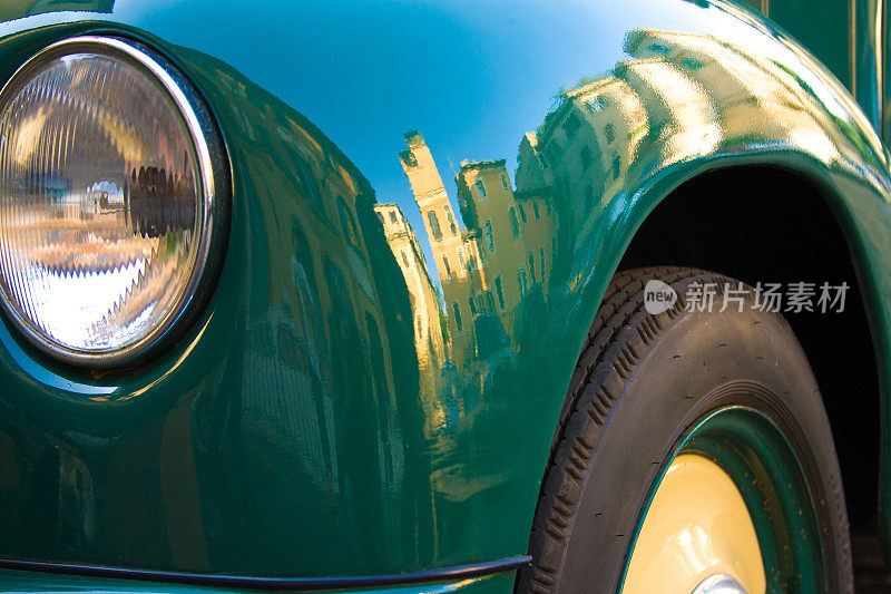 可爱的老式绿色汽车(特写)，罗马天际线反射
