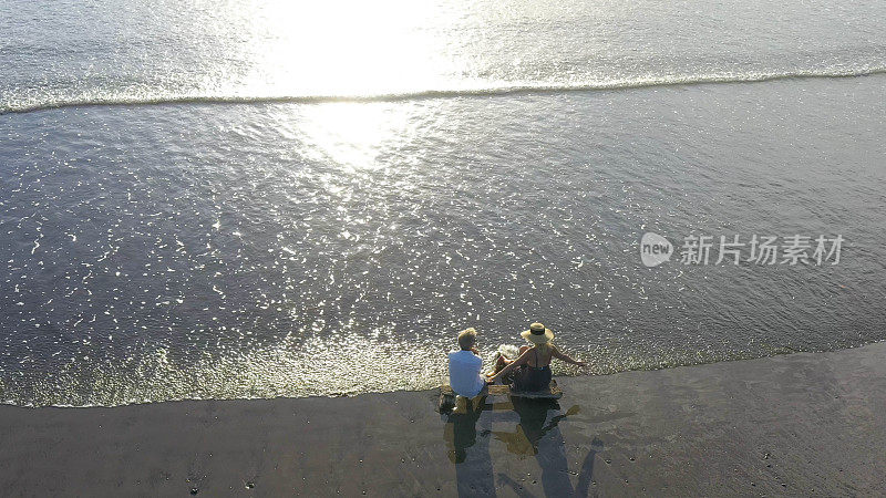 鸟瞰早晨在海滩上放松的成熟夫妇