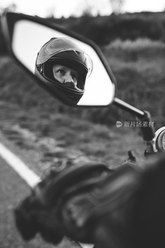 后视镜里的摩托车手。骑着经典的摩托车穿越乡村。