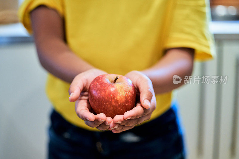 一个男孩在家里手里拿着一个苹果的剪影