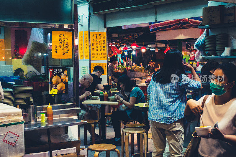人们晚上在香港的露天街边小吃店吃饭