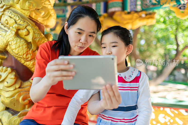 小女孩和妈妈在玩IPAD