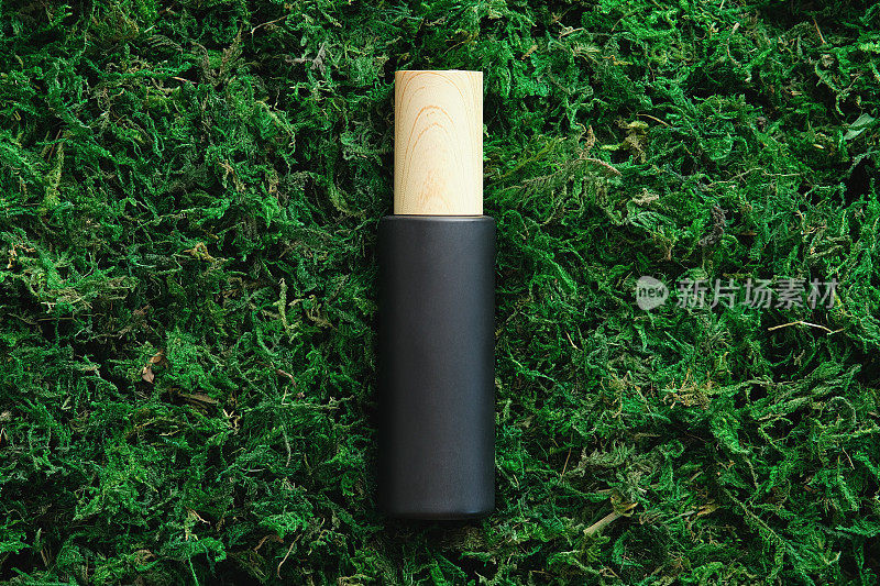 黑色化妆品容器苔藓背景在森林。自然环保美容产品品牌、包装设计。