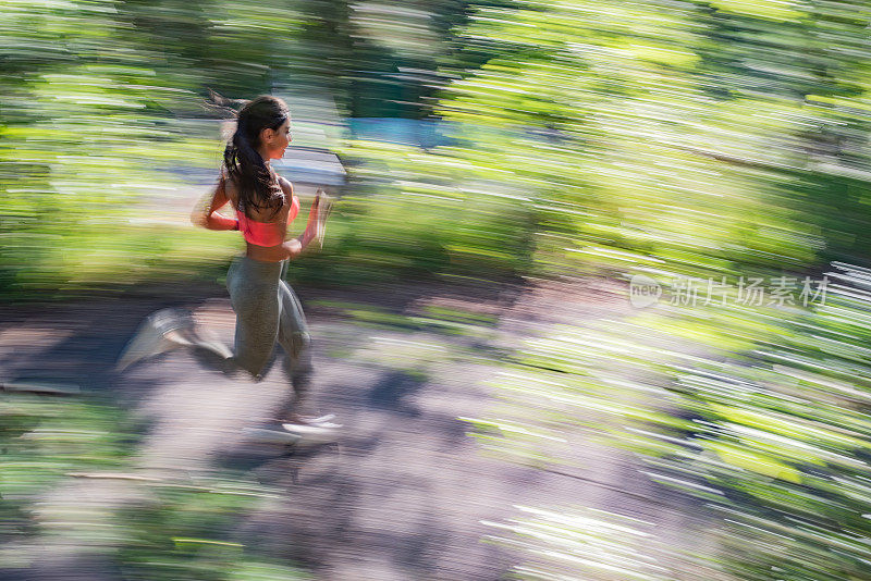 一个女人在阳光的森林里奔跑