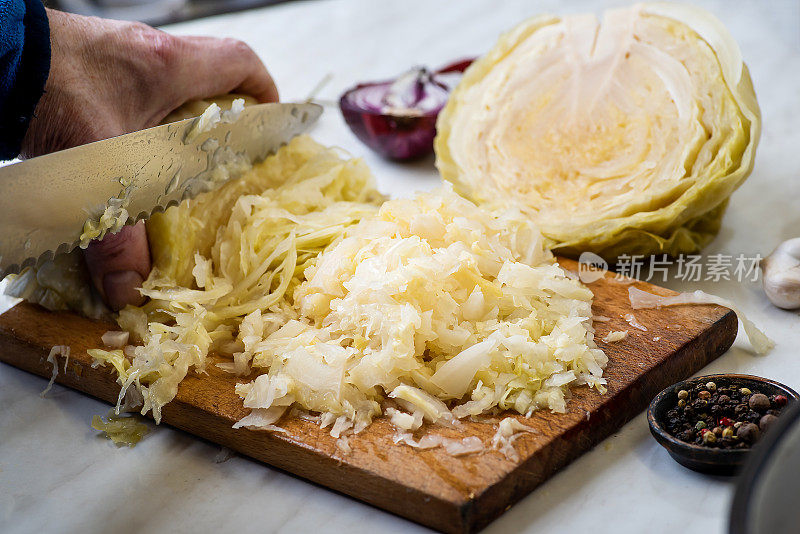 男人在砧板上用手切酸菜