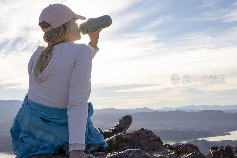 女徒步旅行者在阳光明媚的山脊上休息