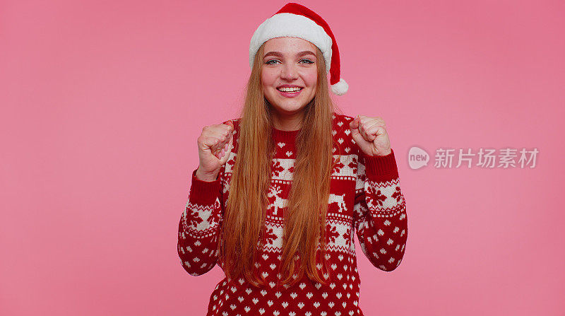穿着红毛衣的快乐女孩圣诞老人大喊大叫，庆祝成功、胜利、目标实现