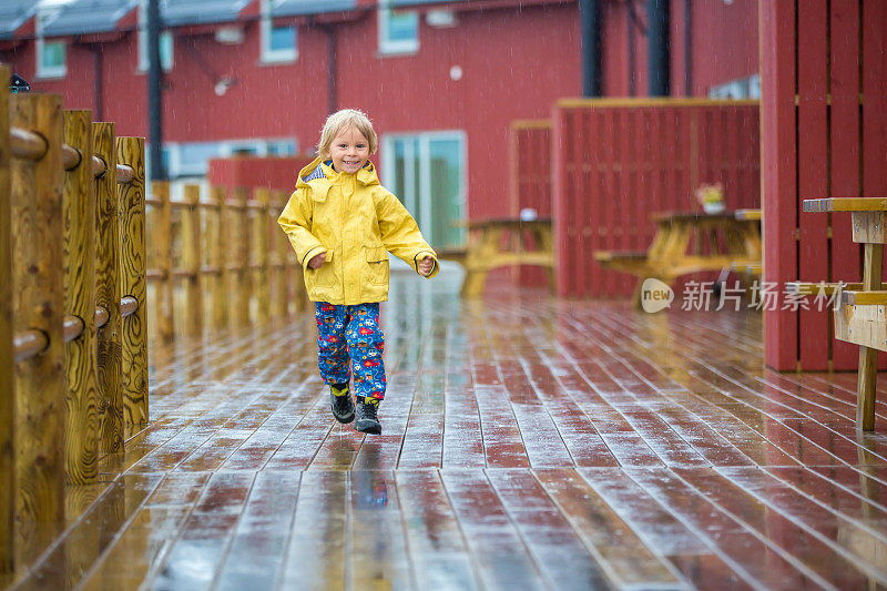 可爱的孩子，在下雨天享受着小渔村