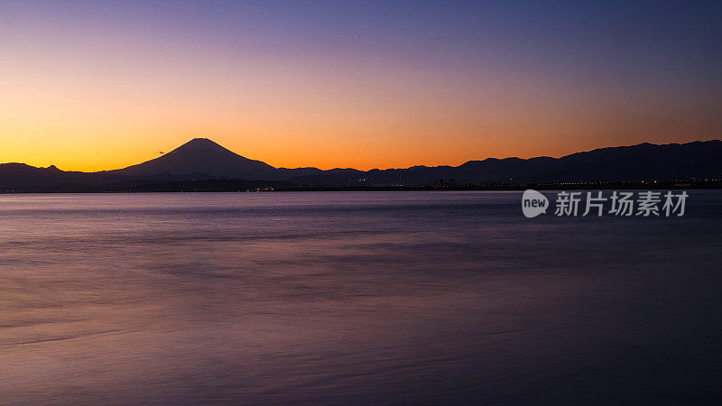 夕阳下，沙滩上的富士山轮廓