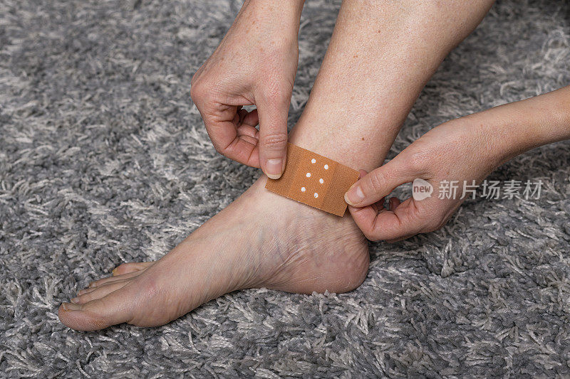 一名女子在受伤的脚踝上贴上膏药