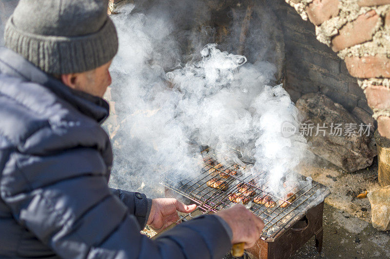 男人在烧烤时做肉丸