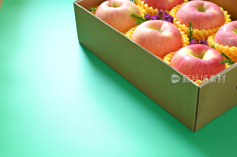 绿色背景的盒子里有漂亮的粉色苹果
