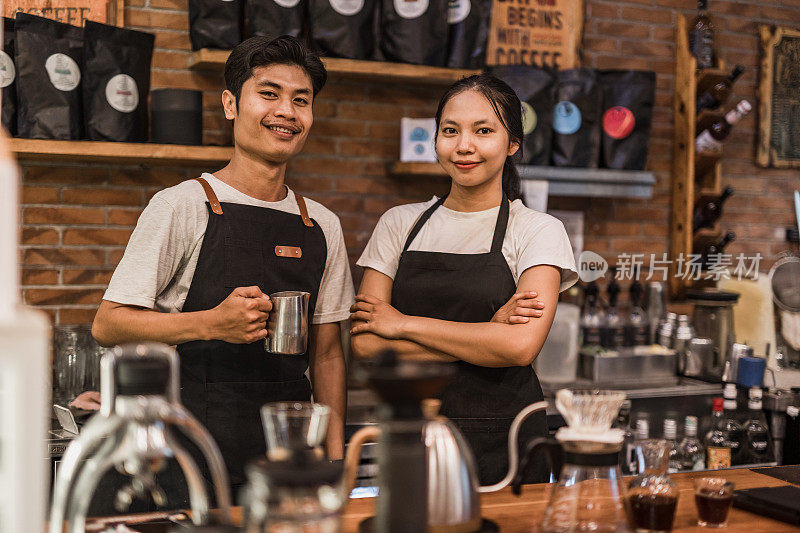 在巴厘岛一家传统咖啡馆工作的一名亚洲男子和一名女子。