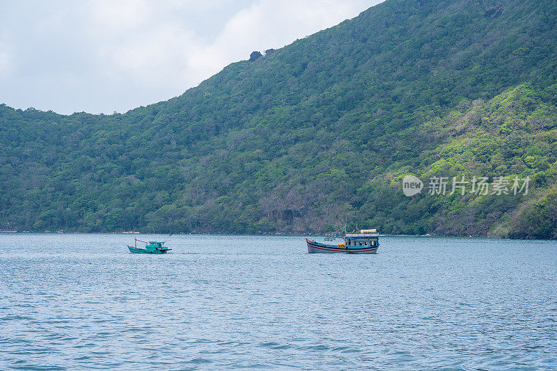 越南孔岛的本坝港，有美丽的碧海蓝天山和五颜六色的小船。