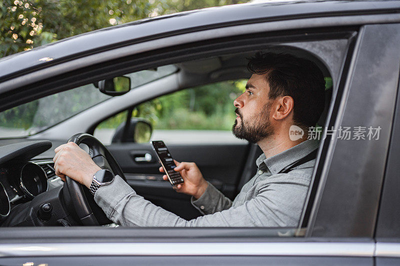 白人商人在开车上班的路上发短信