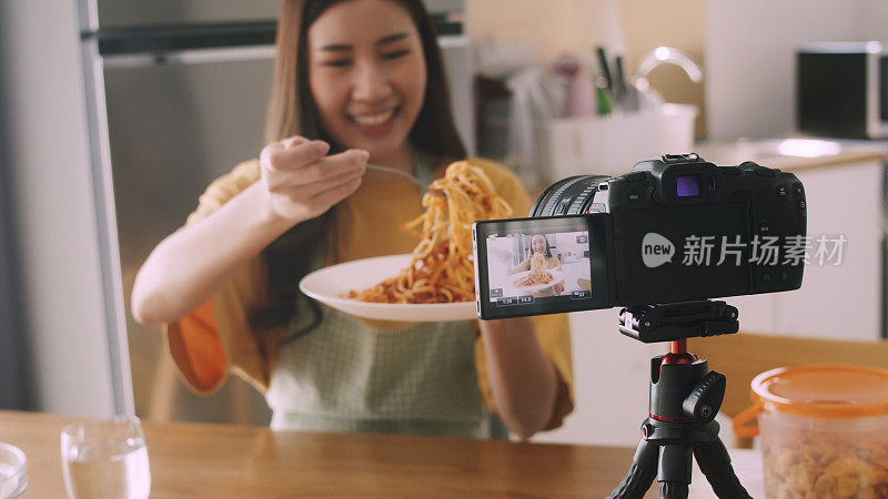 亚洲女性视频博主为美食频道录制视频，并与她的观众交谈。