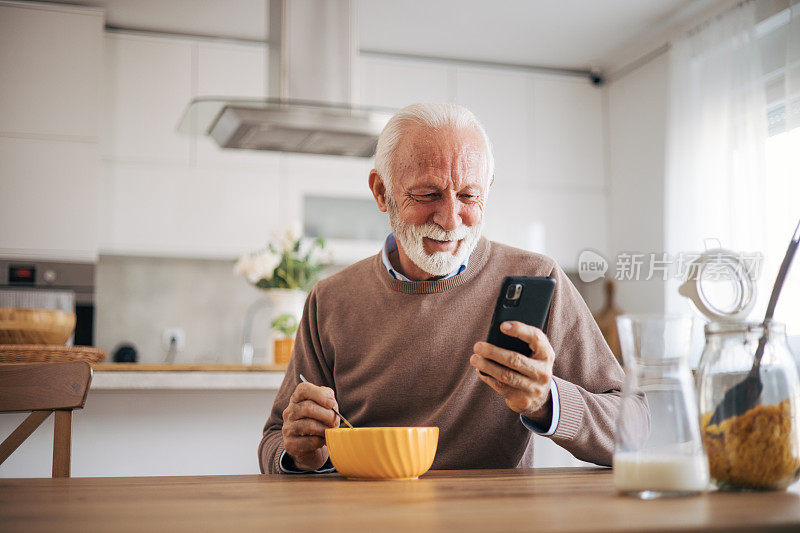 一位快乐的老人正在吃一碗早餐麦片