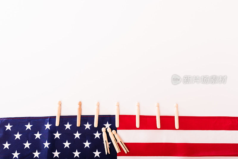 美国国旗用衣夹固定在白色背景上，为文字留出复制空间。
