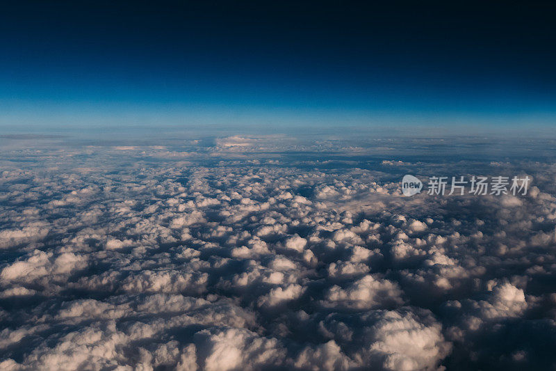 天空上乌云密布。飞机窗外的景色。透过窗户看飞机在飞行中有一个美丽的蓝天