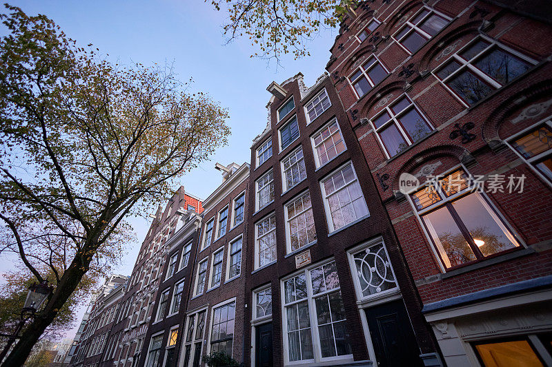 黄昏时分，阿姆斯特丹的城市街道上有历史悠久的运河房屋
