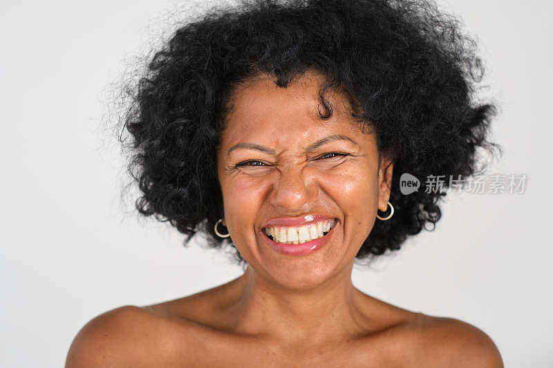 一个优雅而自信的西班牙裔黑人女性看着镜头，笑得很有趣