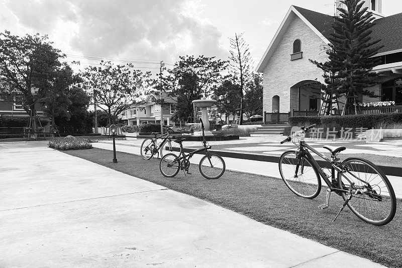 黑白形象的户外开阔空间郊区小镇，自行车，经典建筑，喷泉，公园，显示宁静和孤独的气氛。