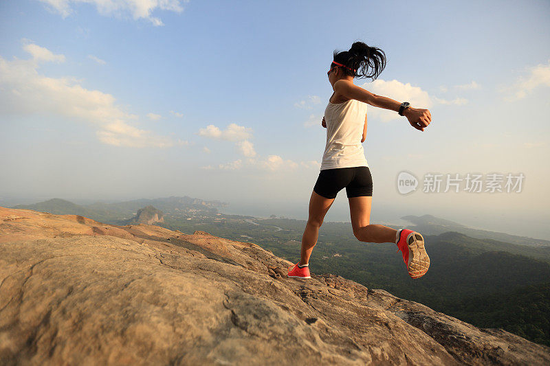 年轻女子在山顶上跑步