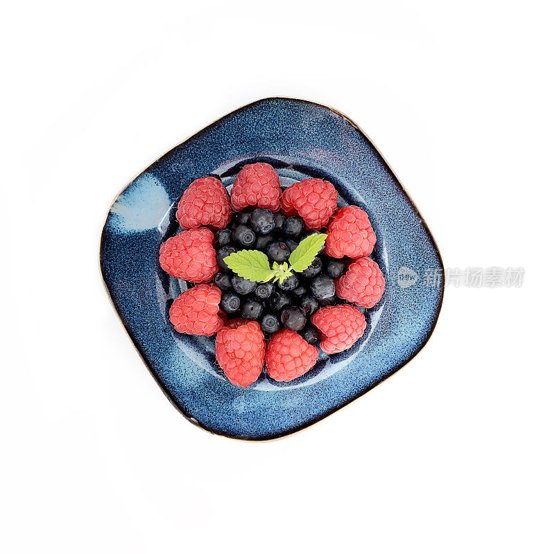 树莓和蓝莓放在一个白色背景的碗里