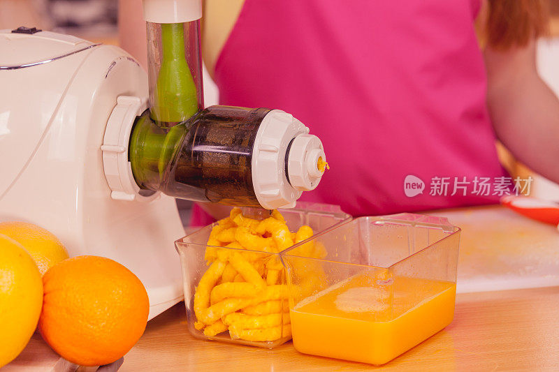 在榨汁机里榨橙汁的女人