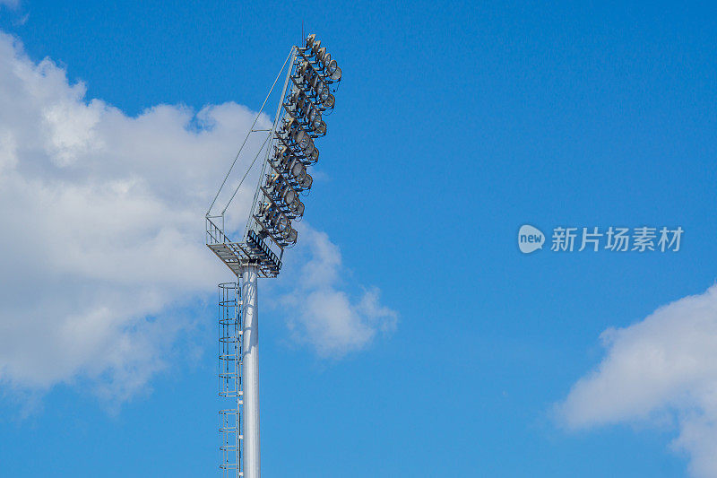 高杆聚光灯体育场灯光与蓝天背景。