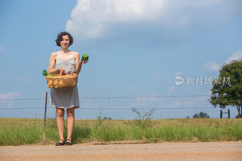 拿着一篮蔬菜的年轻女子