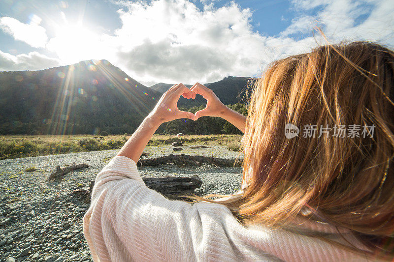 河边的女人做了心形的手指架