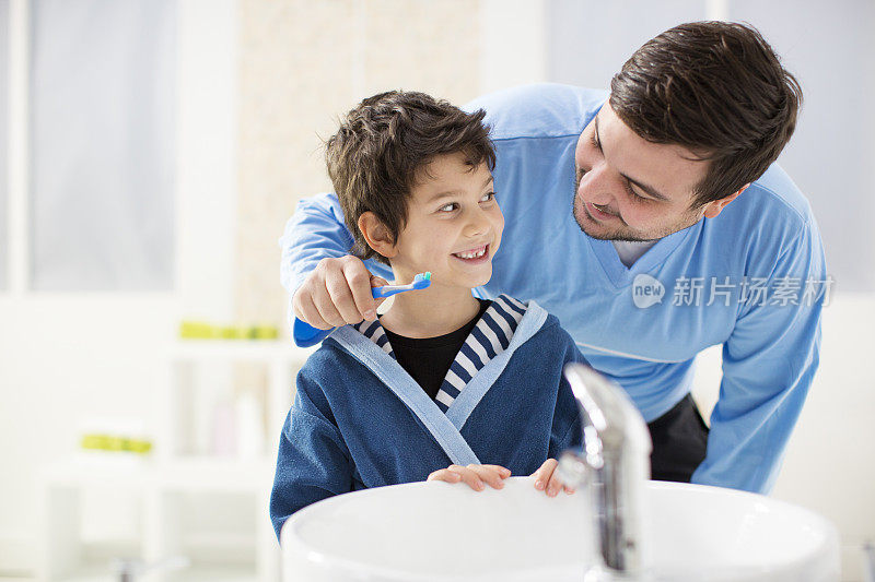 愉快的父子俩在浴室里刷牙。