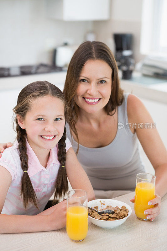 一个女人带着女儿在厨房吃早餐