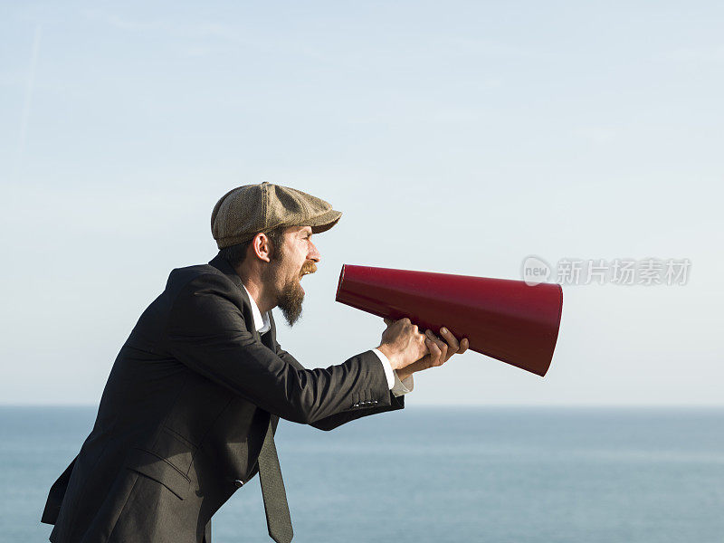 成年男子在室外通过老式扩音器大喊大叫