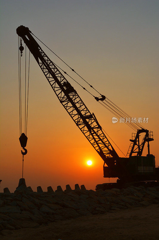 夕阳下建筑起重机的剪影