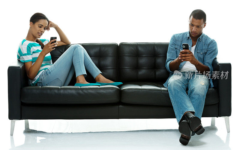 在沙发上玩手机的情侣