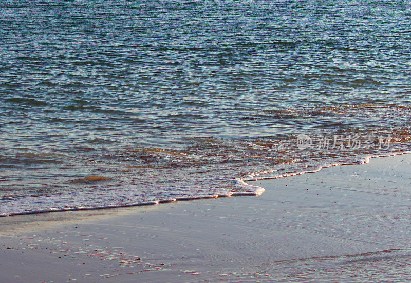 温柔的海浪拍打海滩海岸的特写图像