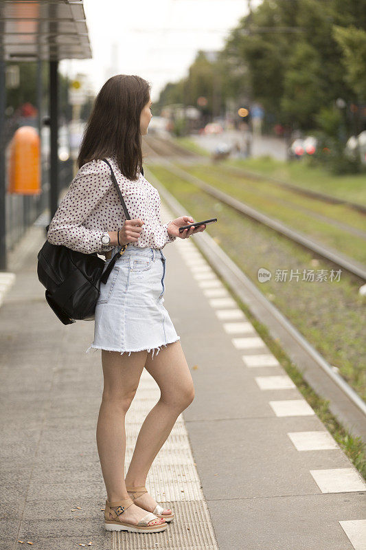 柏林一名女子拿着智能手机等电车