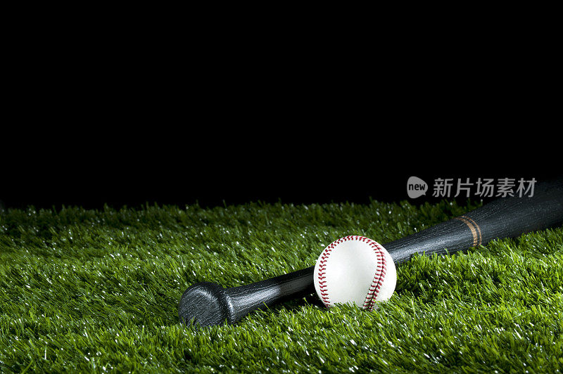 草地上的棒球和球棒
