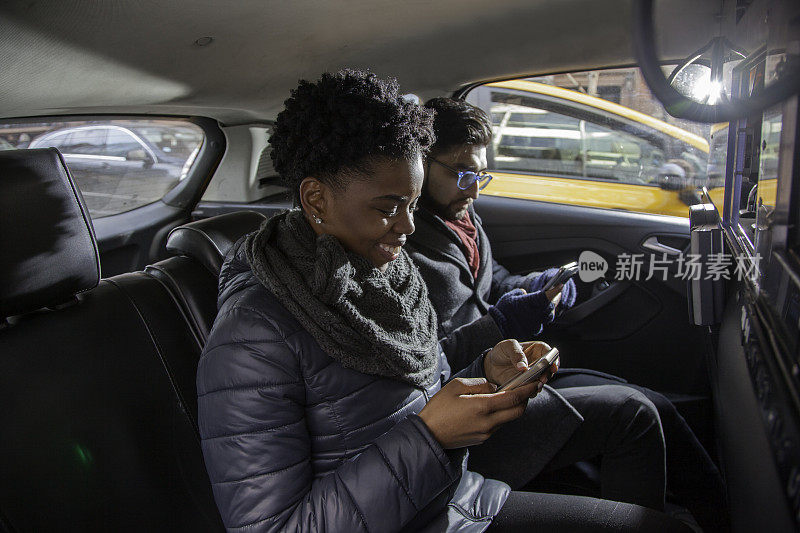 多民族夫妇在出租车上使用手机