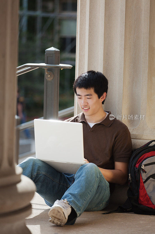 快乐的亚洲青年学生在大学校园工作