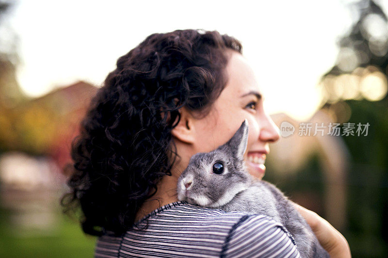 可爱的西班牙女人微笑着，手里抱着一只兔子